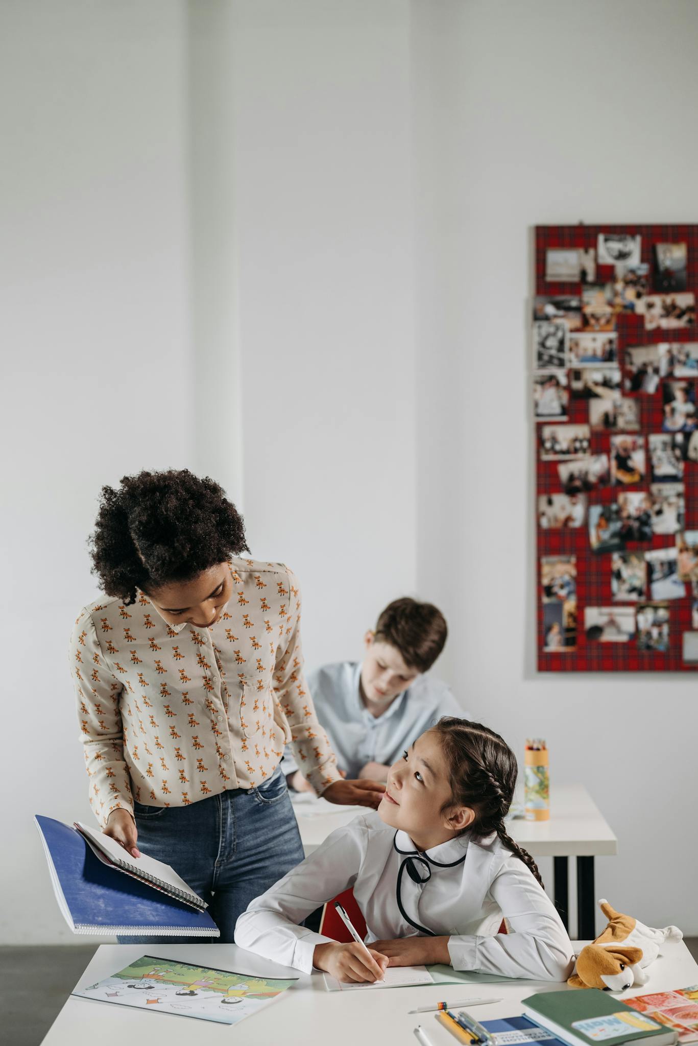 A diverse classroom scene showing a teacher assisting students during a lesson.